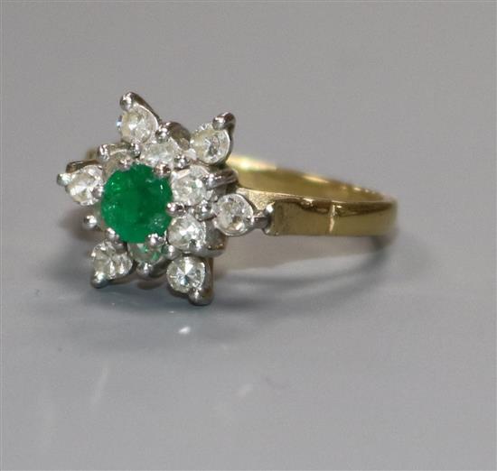 An 18ct gold, emerald and diamond flower head ring, size N.